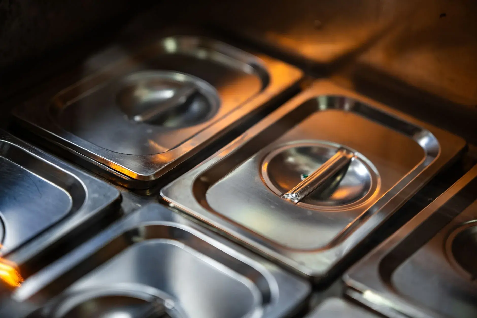 Stainless-steel food warmers in a professional kitchen setting.