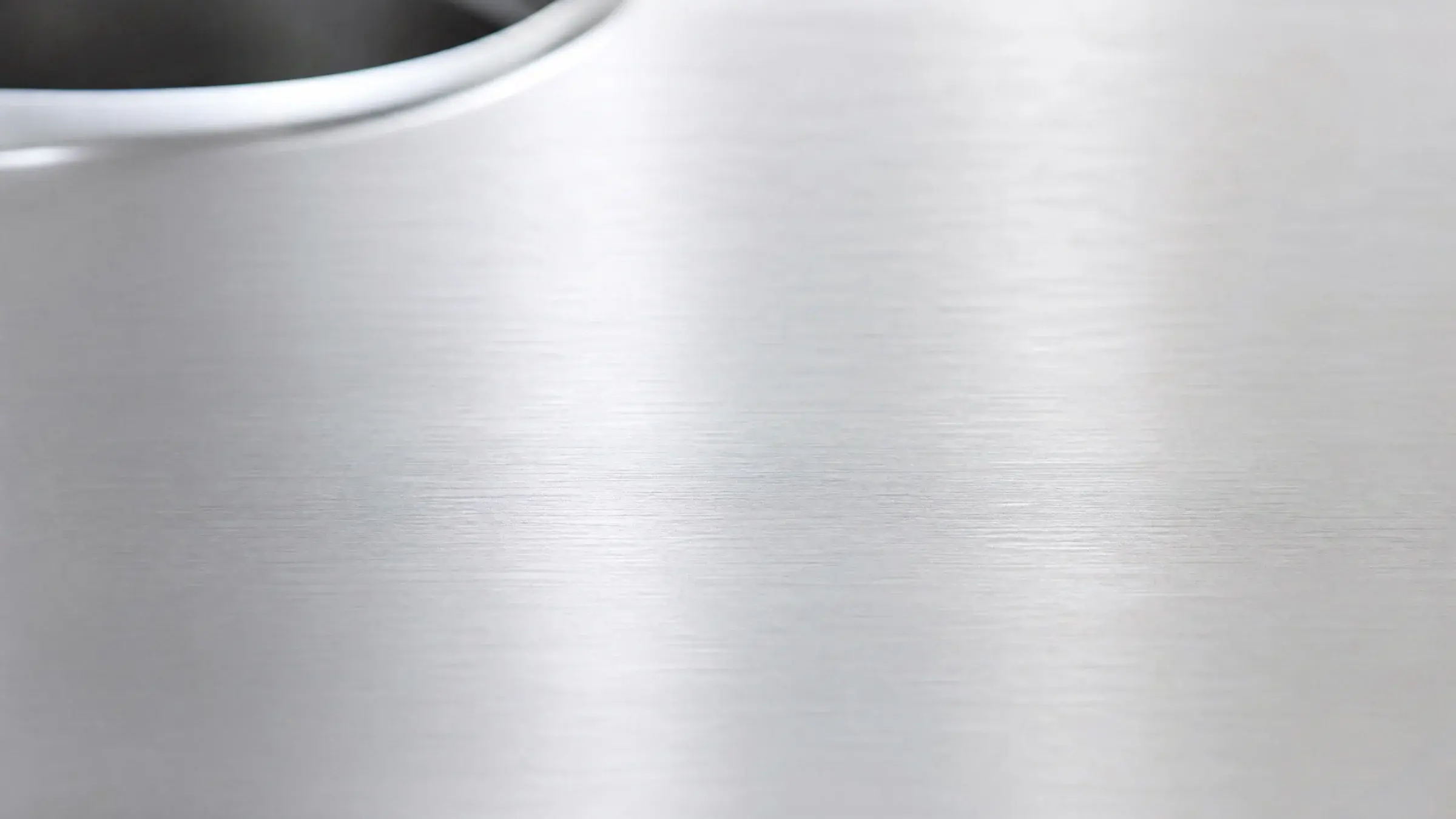 Brushed 304L stainless steel surface in soft natural light
