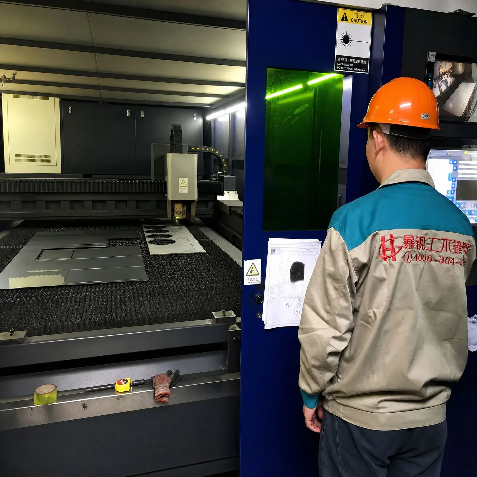 STEELHUI engineer working from part drawings at a fiber laser cutter