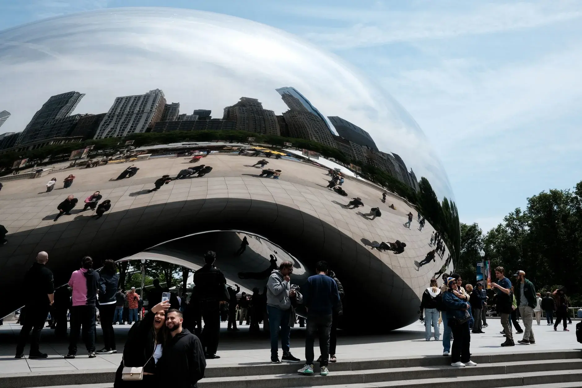 A reflective public sculpture demonstrates image distortion across a formed surface.