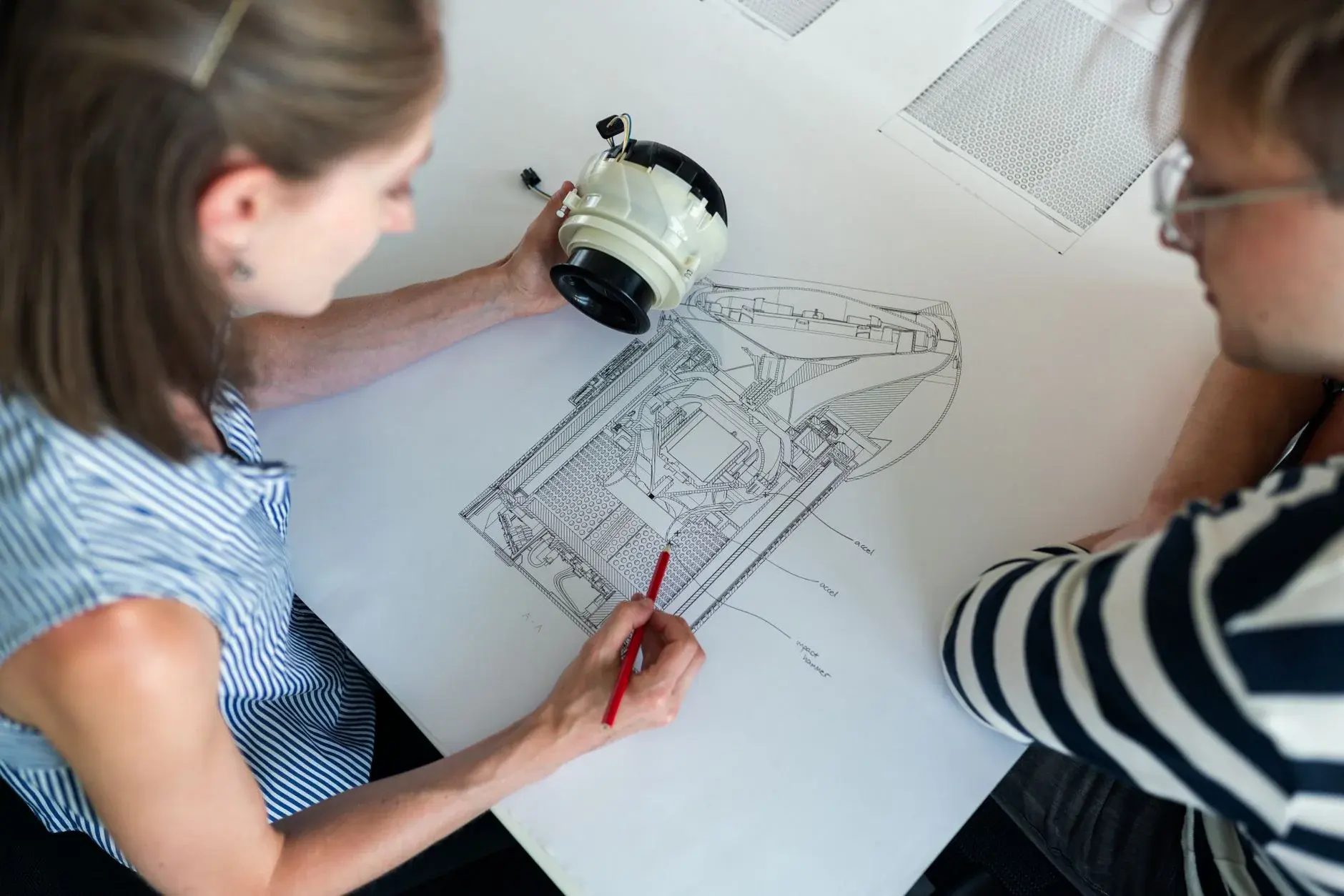 Engineers review a detailed equipment drawing during design work.