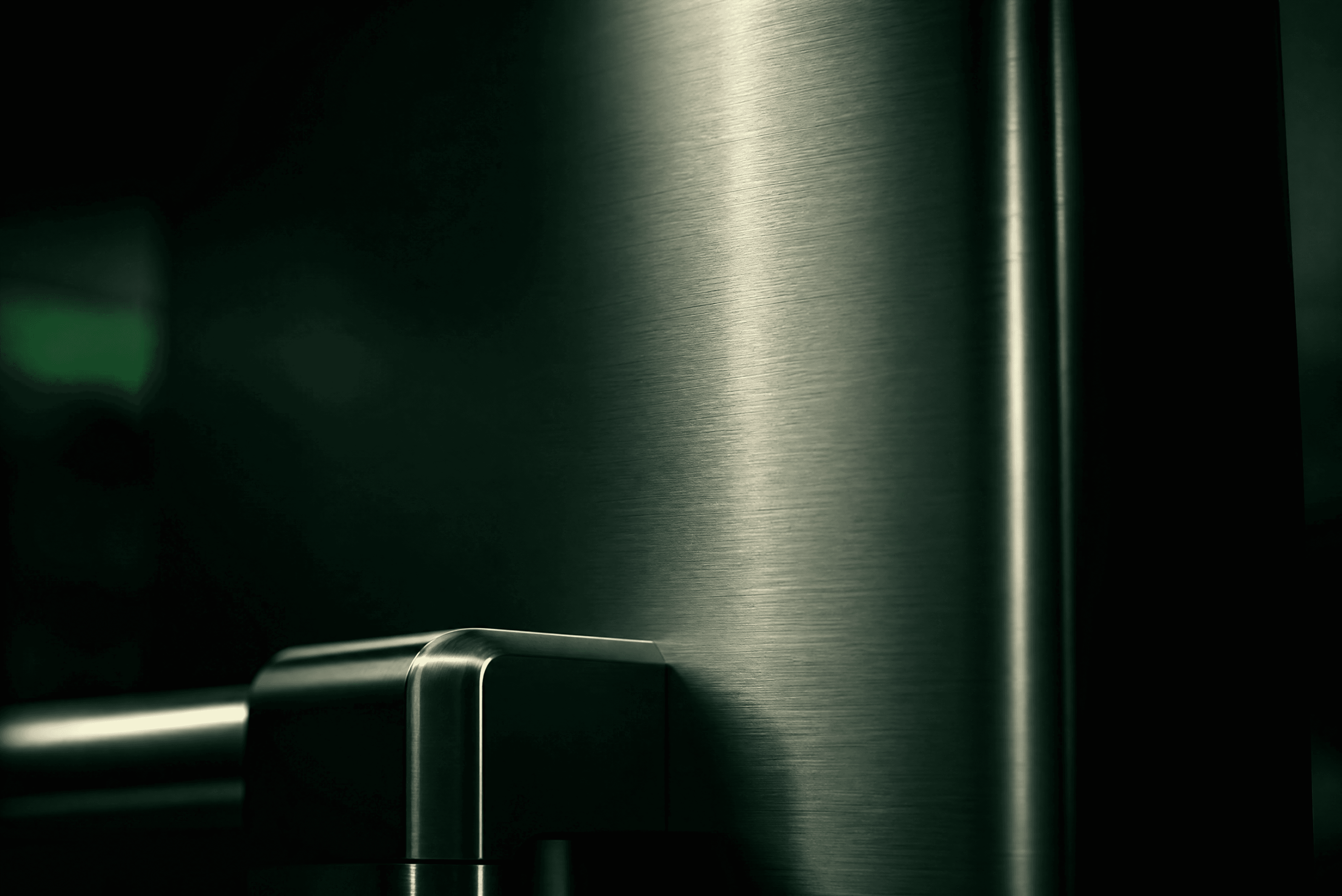 Brushed 316 marine-grade stainless steel surface in a deep-green industrial setting