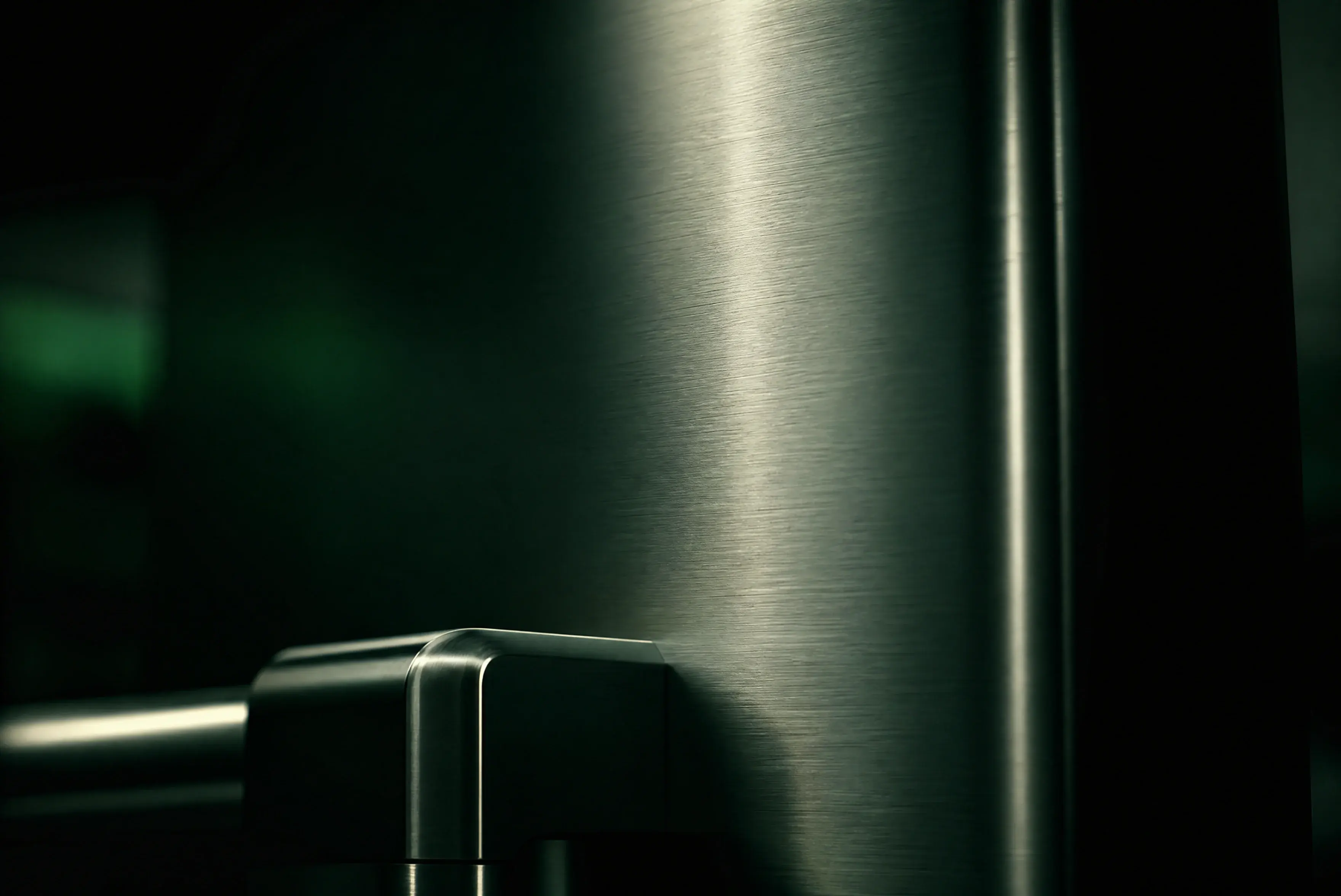 Brushed 316 marine-grade stainless steel surface in a deep-green industrial setting