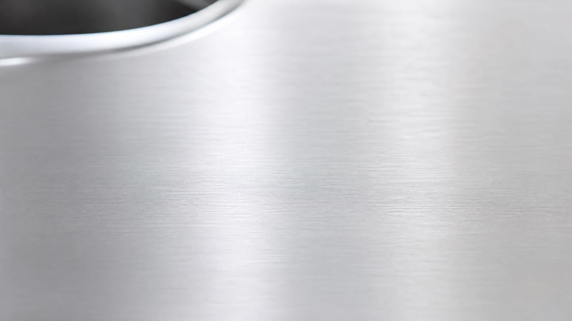 Brushed 304L stainless steel surface in soft natural light