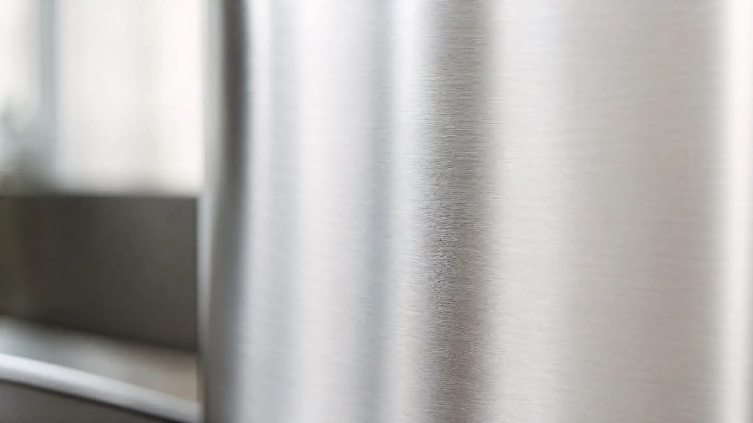 Brushed 316L stainless steel surface in soft natural light