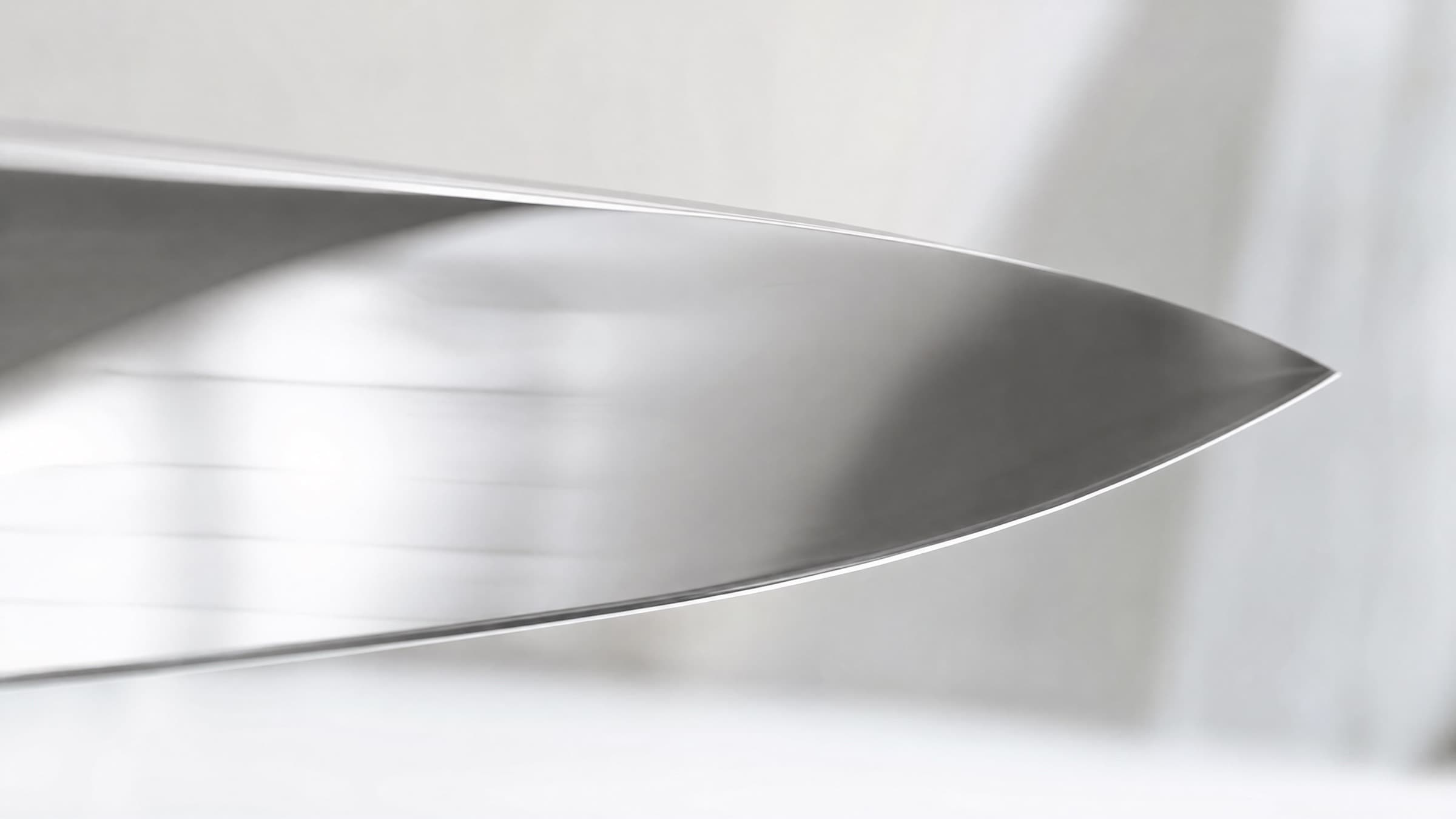 Brushed 440C stainless steel surface in soft natural light