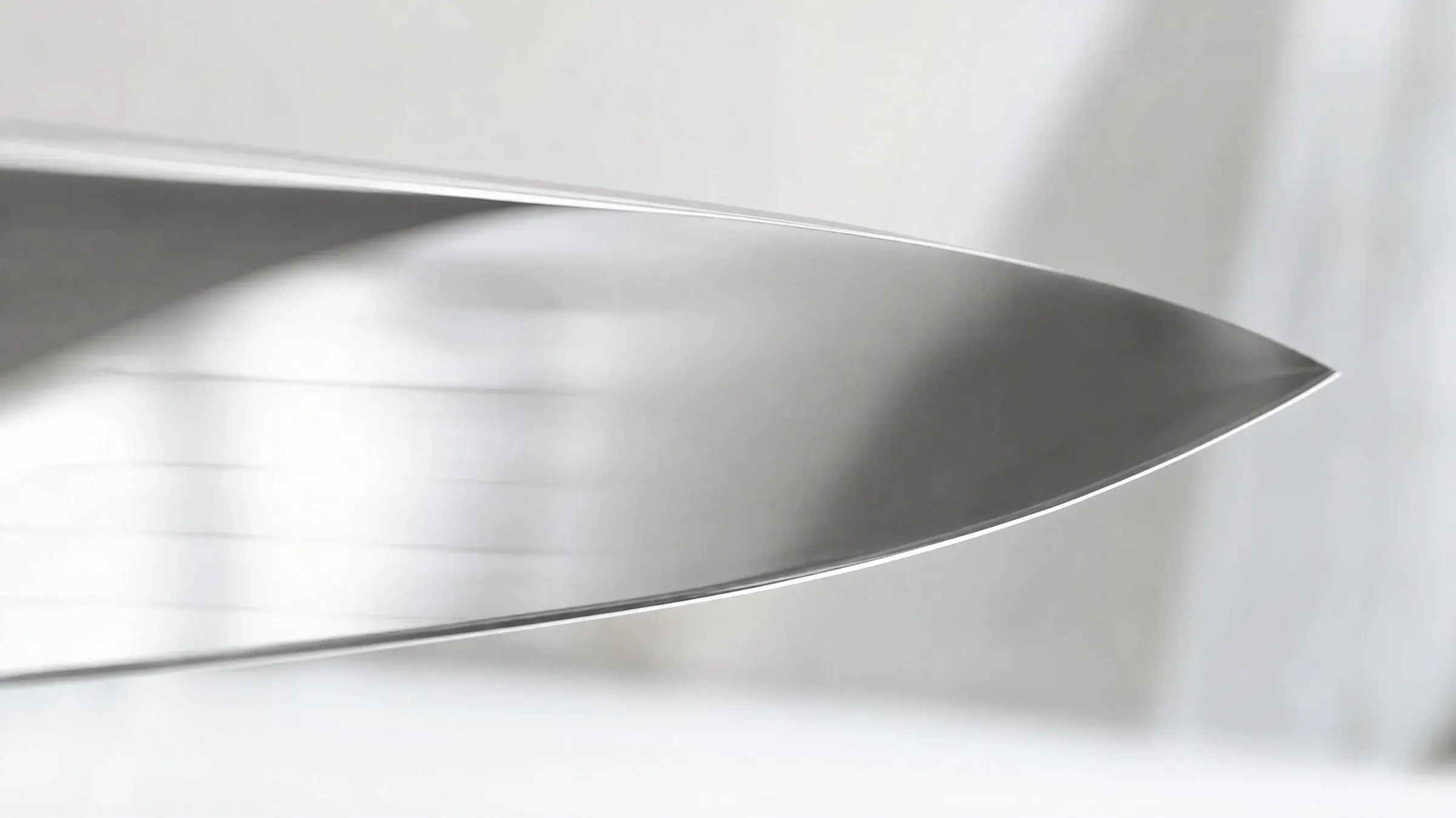 Brushed 440C stainless steel surface in soft natural light