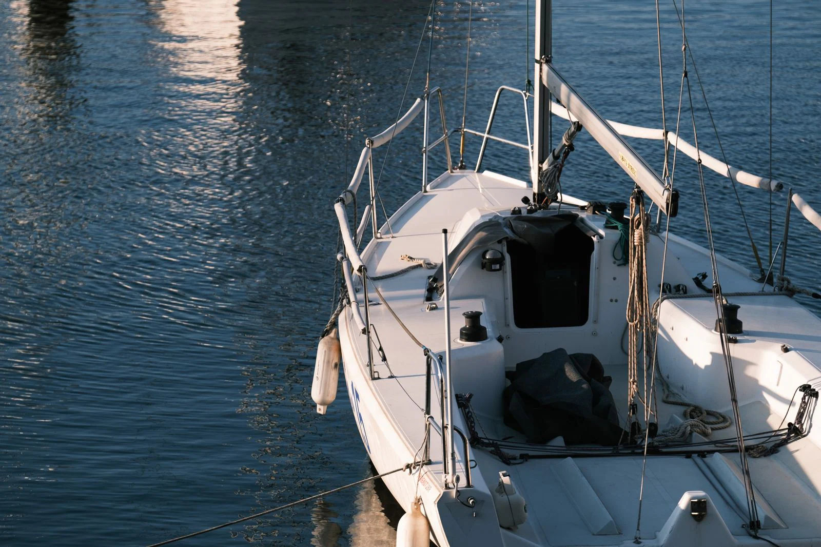 Marine-grade stainless steel rigging and hardware on a boat against the sea