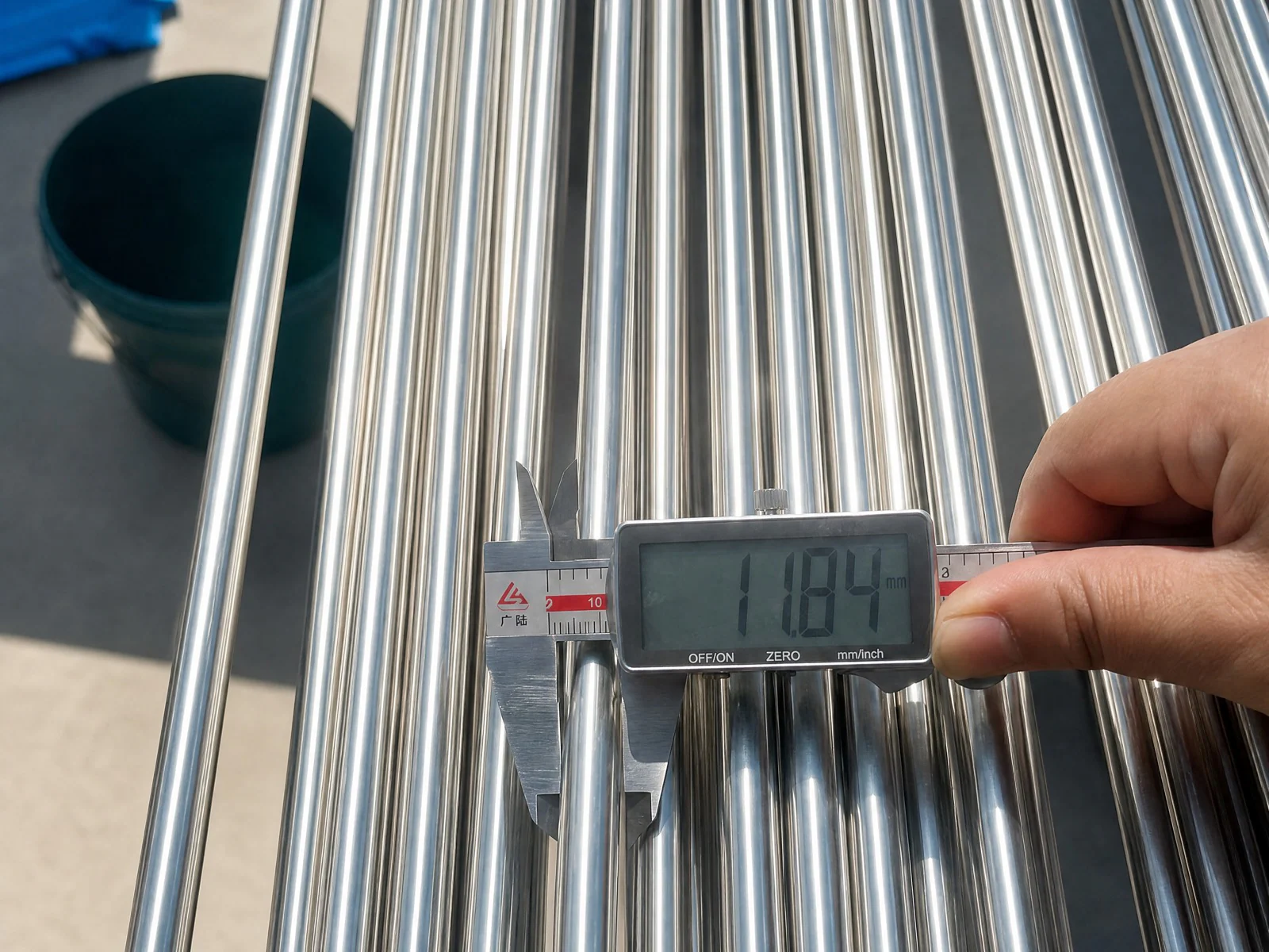 Digital caliper measuring the outside diameter of a STEELHUI 430 stainless steel tube.