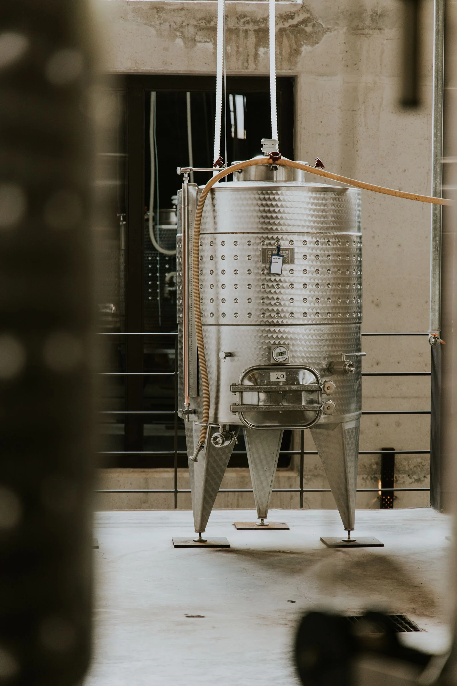 Large stainless steel process tank in an industrial setting